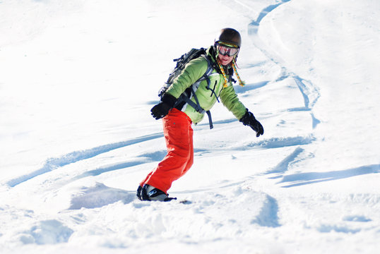 Young woman on snowboard at sunny day
