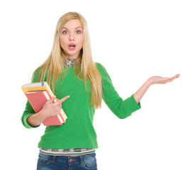 Surprised student girl pointing on empty hand
