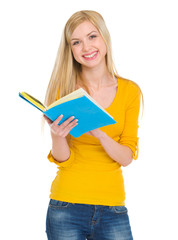 Smiling student girl reading book