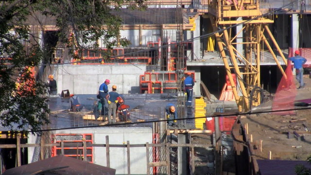 Workers at a construction site set formwork