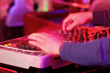 Dj mixes the track in the nightclub at a party