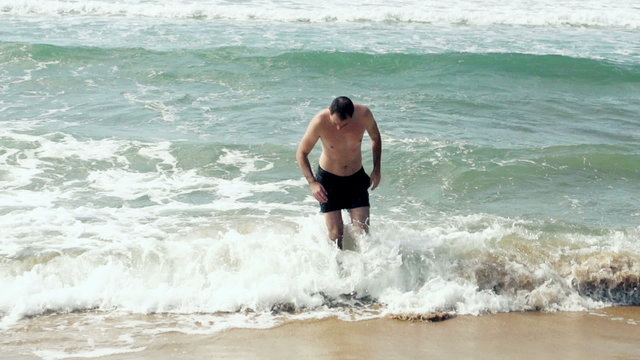 Young man getting out of the sea, slow motion shot at 240fps