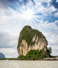Dramatic sky over Thailand Sea with Big Rock and Vegetation