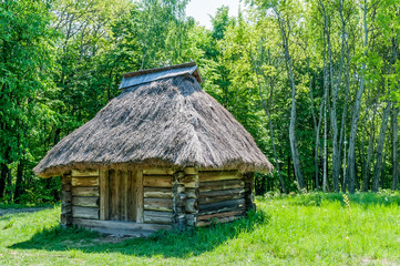 Fototapeta na wymiar A typical antique Ukrainian wooden country hut with a thatch roof, in Pirogovo near Kiev 