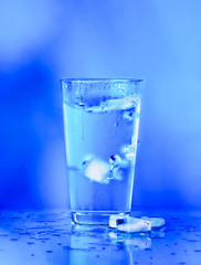 Glass of water on blue background. water with ice in glass