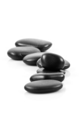 Black massage stones stacked, isolated.