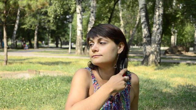 young woman brushing her hair in a park