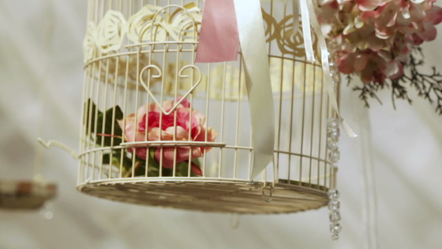 Decorations for wedding ceremony in a hanging decorative cage