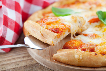 Slice of homemade pizza being lifted