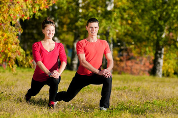 Man and woman woman doing yoga in park