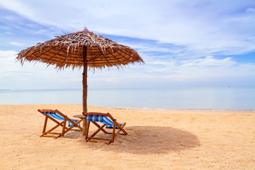 Tropical beach scenery with parasol and deck chairs in Thailand