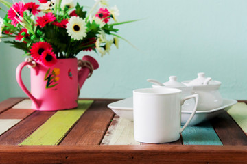 White cup of coffee on colorful wood table