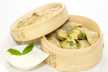 dumplings with sour cream in a wooden bowl