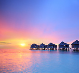 Naklejka premium View of a beautiful sunset on a Malidves island and water villas