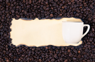 Coffee mug on a sheet of old paper on the background of coffee b