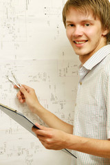A young man near a diagram, measuring