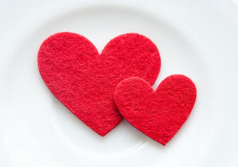 Fototapeta na wymiar Red hearts on a plate close-up. Valentine's Day