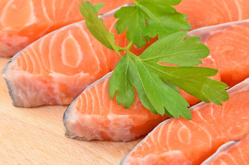 Fresh salmon steak slice on wooden background, DOF