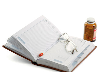 book and pot of capsule pills isolated on white background