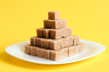 Unrefined sugar on a yellow background