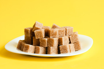 Unrefined sugar on a yellow background