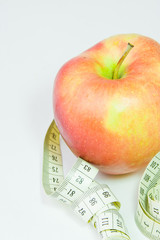 red apple and centimetre on a white background