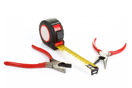 red pliers and measuring tape isolated on white