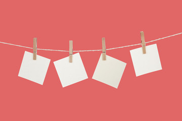 Blank paper cards hanging on clothespins 