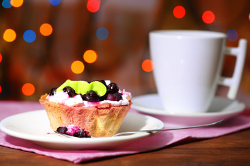 Tasty blackberry cake and cup of beverage,
