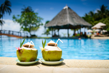 Pina colada drink in front of pool - obrazy, fototapety, plakaty