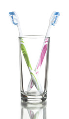 colorful toothbrushes in a glass over white