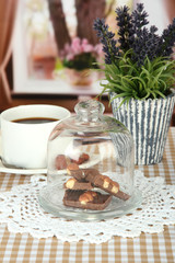 Chocolate pieces under glass cover and hot drink