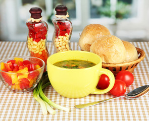 Fragrant soup in cup on table in kitchen