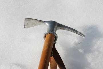 Toy axe stuck in the cold snow in the mountains in winter