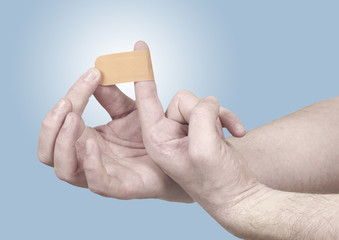 Hand putting adhesive bandage on index finger