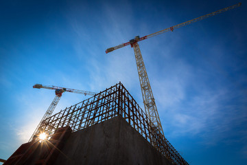 Construction site with cranes on sky background