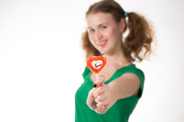 closeup shot of girl with red heart lollipop isolated on white