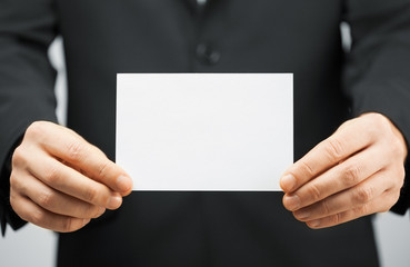 man in suit holding blank card