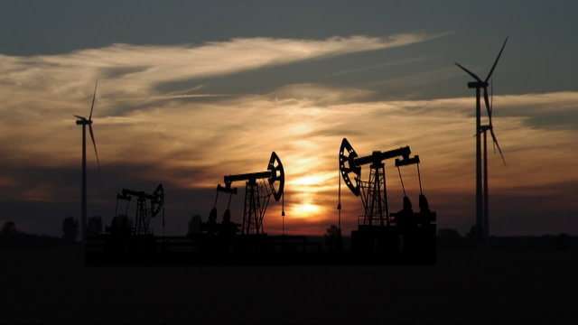 pump and wind turbine on sunset background
