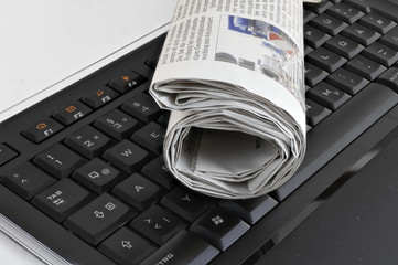Zeitung gerollt auf Tastatur