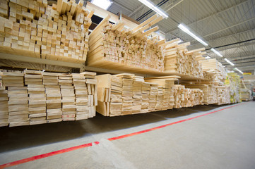 Lumber boards and beams of different sizes lie on racks and pall