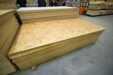 Plywood of different sizes lie on racks and pallets in build sup