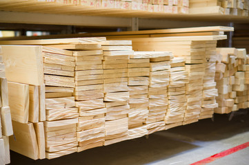 Lumber boards and beams of different sizes lie on racks and pall