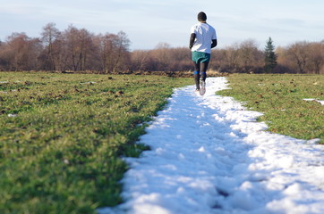 Mężczyzna biegający po pasie śniegu - obrazy, fototapety, plakaty