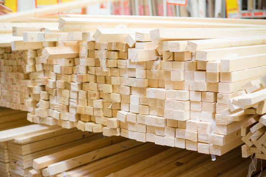 Lumber boards and beams of different sizes lie on racks and pall