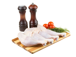 Fresh raw chicken wings on chopping board with roma tomatoes