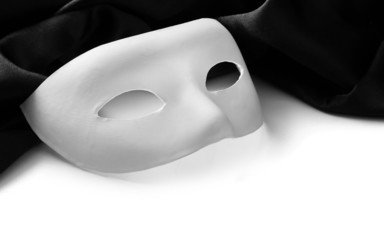 White mask and black silk fabric, isolated on white