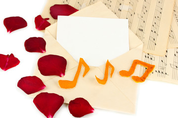 Old envelope with blank paper and dried rose petals