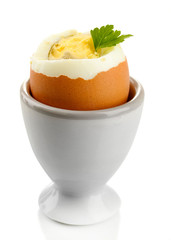 Boiled egg in egg cup, isolated on white