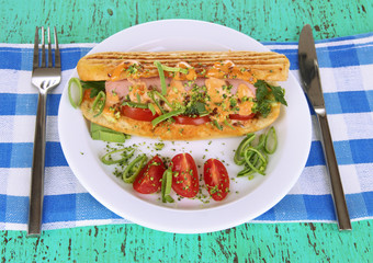 Delicious hot dog on plate on wooden table close-up
